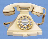 Front view of the beige Microtel Model 944 pushbutton landline phone showing number keypad with redial and hold buttons and handset on cradle.