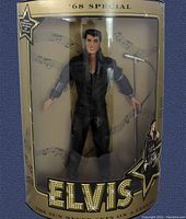 Front view of Elvis Presley '68 Special doll in original packaging with microphone stand and decorative box featuring musical notes