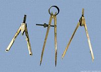 Three vintage German metal compass drafting tools arranged together on a gray surface showing their design and condition.