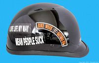 Side view of black vintage motorcycle helmet showing stickers "I Live Life My Way," "Mean People Suck," and "Bike Week 97 Daytona USA"