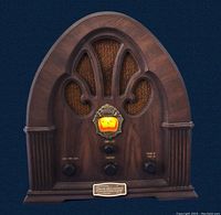 Full front view of vintage Philco-Ford radio with wooden cathedral-style cabinet and central illuminated tuning dial.
