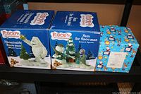 Boxes of three Enesco Rudolph the Red Nosed Reindeer figurines side by side, showing their new boxed condition.