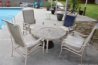 Front view of round mosaic tile fire pit table with four mesh sling chairs