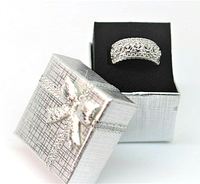 Wide shot of the silver-tone gift box with bow and the sterling silver multi-stone cocktail ring inside.