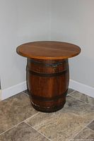 Full view of the whiskey barrel table showing round wooden top and barrel base with metal bands and handles