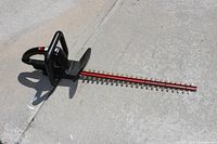 Full view of the Craftsman electric hedge trimmer showing black housing and red 22-inch cutting blade.