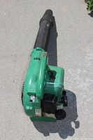 Top view of the green handheld blower showing black blower tube and body.