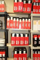 Multiple wooden shelves filled with red and black G-Force Racing Gear Racing Suit boxes