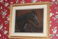 Full view of watercolor painting of horse and foal in ornate gold frame on floral wallpaper background.