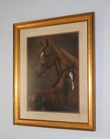 Front view of entire framed watercolor painting depicting a horse and foal