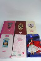 Six boxed Barbie dolls including Valentine-themed Barbies and dolls in elegant attire.