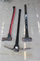 Overall view of the pick axe, sledge hammer and axe laid on concrete ground, showing condition and design