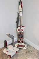 Front view of the Shark Rotator Professional Lift-Away vacuum standing upright with hose and attachments next to it on floor.