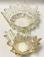 Two Finnish Humppila Revontulet glass bowls in clear textured glass with jagged edges, shown from above to capture shape and texture.