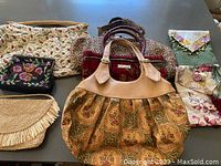 Group photo of eight purses showing variety of materials and styles including tapestry, beaded, leather, straw and fabric with floral designs