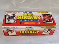 Front and top view of the 1990 Score NHL Hockey Premier Edition collector card box showing its branding and highlighted rookie cards.