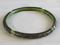 Full round view of bangle showing silver overlay and green inlay
