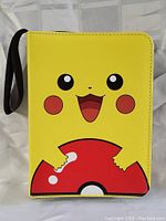Front view of the yellow binder showing Pikachu holding a bitten Pokeball graphic.