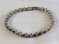 Full view of the sterling silver multi-stone jeweled bracelet laid flat, showing overall design and length.