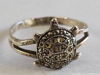 Close-up of the turtle design ring showing the marquisette stone details and split shank band.