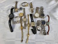 Wide angled image showing all 12 watches laid out on a white cloth background, highlighting the different styles, bands and dial colors.