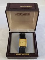 Wittnauer men's wristwatch displayed in a branded brown case with cream interior.