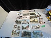 Photo showing 20 antique and vintage Hamilton postcards laid out on a table with various images of buildings, streets, and aerial views.