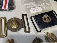 Brass Pro Patria circular belt plate and blackened Middlesex Regiment belt buckle in plastic bag