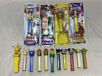 Top-down view of 14 PEZ candy dispensers; 10 loose and 4 in original packaging with Toy Story 4 theme characters.