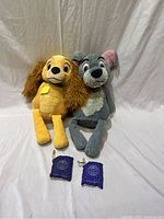 Two Scentsy plush warmers of Lady and Tramp with two purple scent pouches in front.