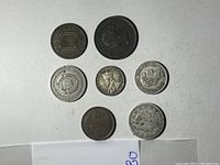 Seven assorted coins with Queen Elizabeth II profile, numeric denominations, and historic crests on a white background.