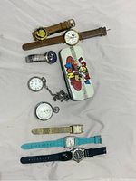 Overview of 8 vintage watches including 5 wristwatches, 2 pocket watches with chains, and a Looney Tunes metal tin box.