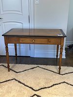 Front view of pine table showing top surface, drawer, and turned legs