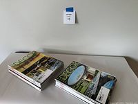 Two piles of Elle Decor magazines placed side by side on a table with a wall in the background.