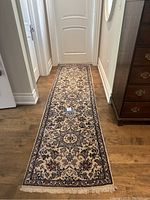 Full-length view of narrow runner rug placed in hallway on hardwood floor