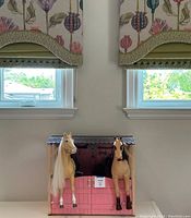 Stable with two horse figures placed in front, closed doors