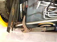 Photo showing assorted saw blades, including circular saw blades and hand saw blades, along with metal brackets and blade caddy inside tote