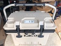 Front angled view of the cooler showing metal handle with padded grip and rubber feet at base for nonslip stability.