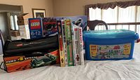 Overview of all the items showing Lego boxes, black soft Lego Racers Fuel 4 Speed bag, books and blue Lego storage container