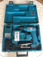 Open carrying case showing Makita cordless drill, Faat charger, two batteries, and drill bits.
