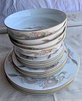 Stack of mixed plates and bowls showing the Imperial Dragon pattern and gold trim