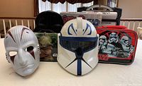 Photo showing multiple Star Wars masks and lunch boxes including Yoda and stormtrooper designs