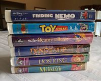 Stacked view of six Walt Disney VHS cases showing spine titles: Finding Nemo, Toy Story, Beauty and the Beast, Dinosaur, The Lion King, The Little Mermaid.