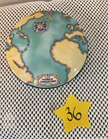 Top view of the lid showing world map design in teal, blue and yellow with compass rose and 'WORLD DISCOVERY' labeling.