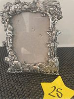 Front view of the rectangular aluminum picture frame showing detailed wildlife motifs including elephants, leopards, birds, and foliage.
