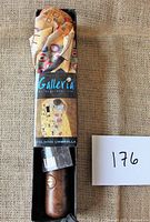 Folding umbrella packaged in the original Galleria box showing the Gustav Klimt The Kiss design on the tag and umbrella fabric.