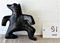 Front view of black stone bear sculpture, showing the bear standing with arms slightly bent.