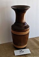 Full view of tall mango wood vase with flared neck and woven detailing bands on body