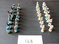 All chess pieces arranged on a black background, showing complete set with both colored sides visible.