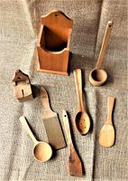 Photo showing a collection of Swedish wooden kitchen utensils including a wall-mounted box holder, spatulas, spoons, ladles, and a small wooden box with lid.